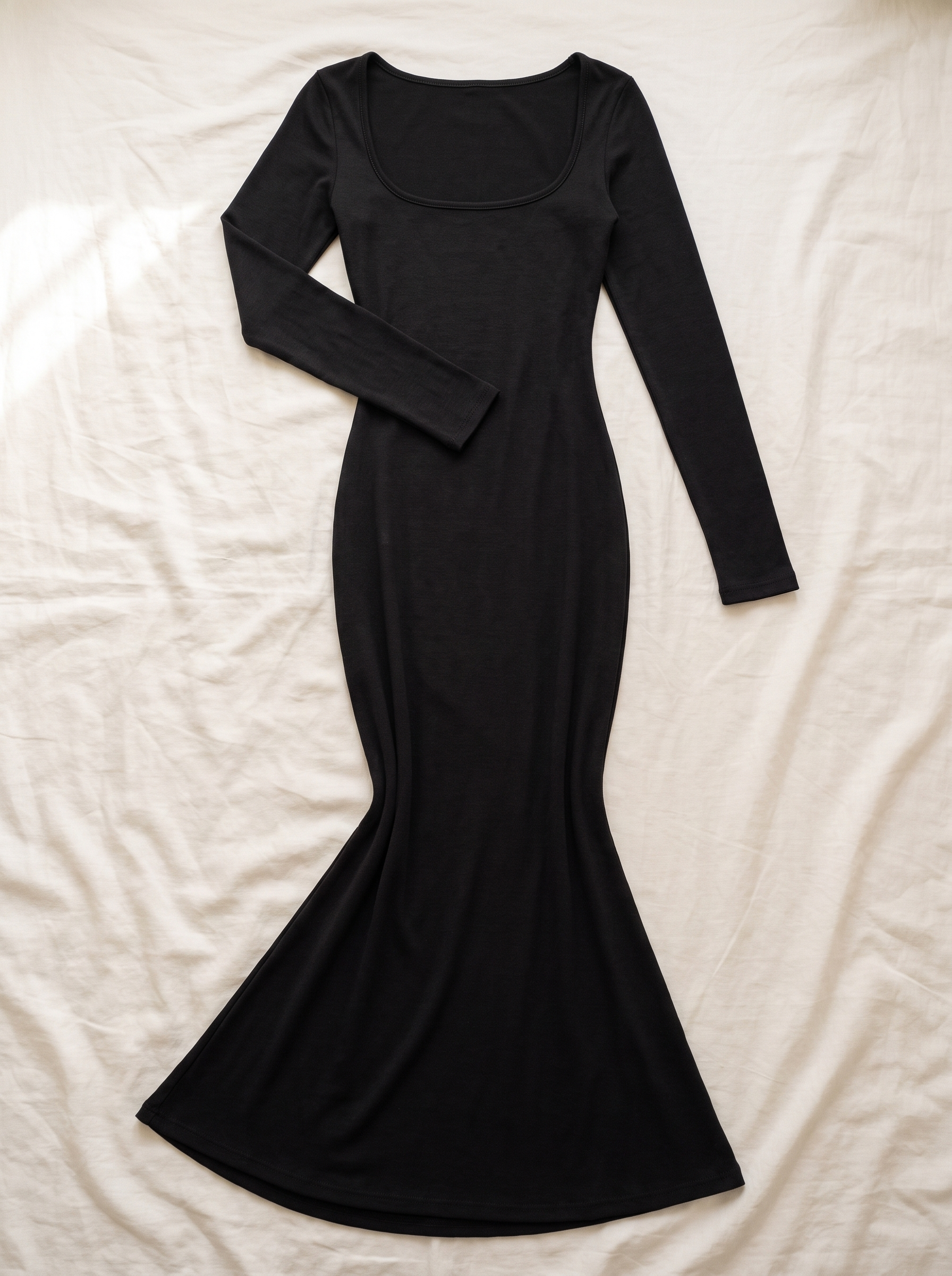 Vestido Esencia negro extendido sobre lino, vista cenital del producto completo