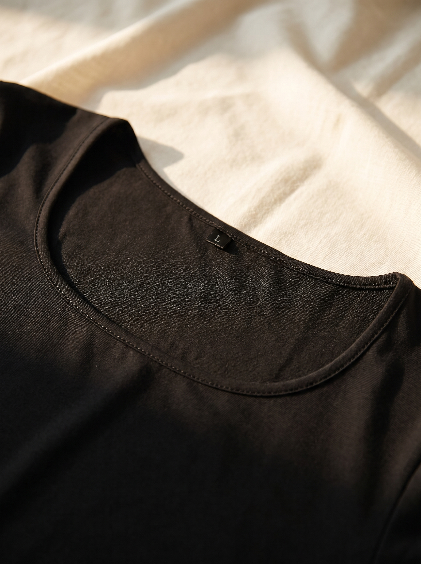 Detalle del escote y ribete cosido del Vestido Esencia negro con etiqueta de talla